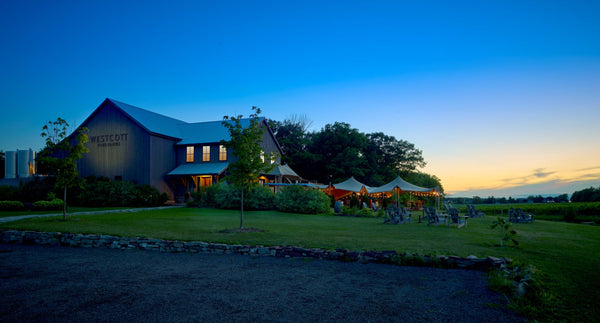 Evening view of the Westcott Vineyards winery and tasting room with patio lit up at sunset.