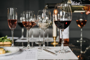 five wine glasses full of different types of wine