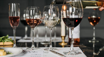 five wine glasses full of different types of wine